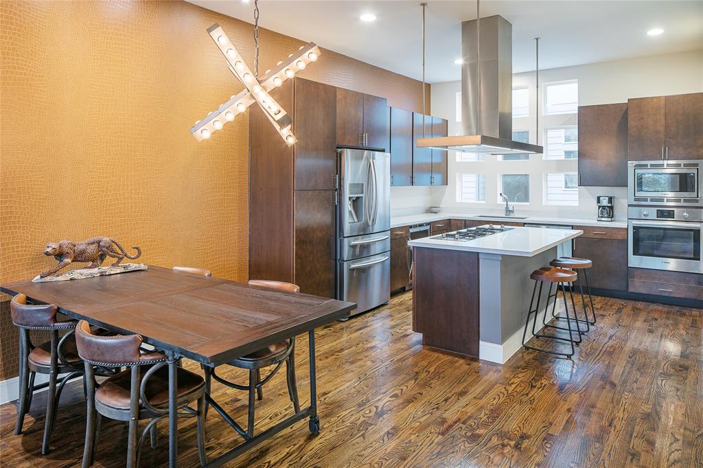 4610 Steel Street Dallas, TX 75219 - Photo 6 of 10 a kitchen with stainless steel appliances granite countertop a table chairs stove and refrigerator