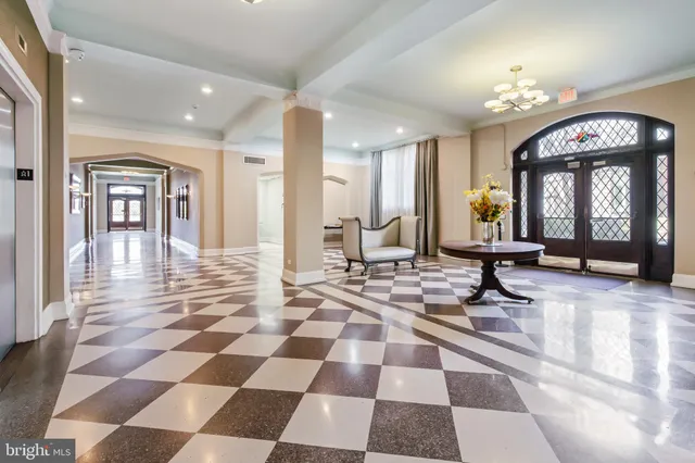 a living room with a black white checkered floor with a gaming machine and dining table