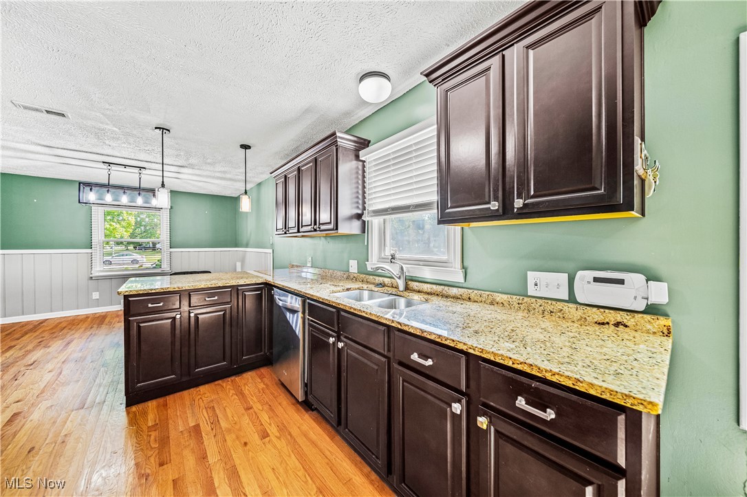1796 Lander Road Mayfield Heights, OH 44124 - Photo 11 of 39 Kitchen with dishwasher, a textured ceiling, sink, light hardwood / wood-style flooring, and decorative light fixtures