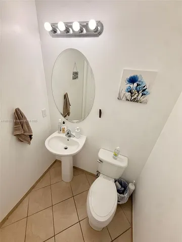 a bathroom with a sink mirror and toilet