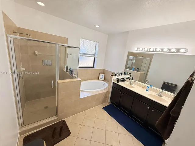 a spacious bathroom with a double vanity sink a mirror and a bathtub