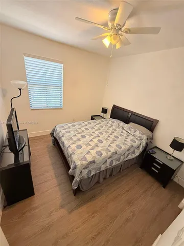 a bedroom with a bed and a ceiling fan