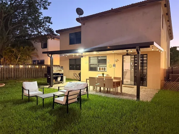 a view of a chairs and tables in the back yard of the house