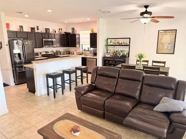 a living room with furniture kitchen view and a chandelier
