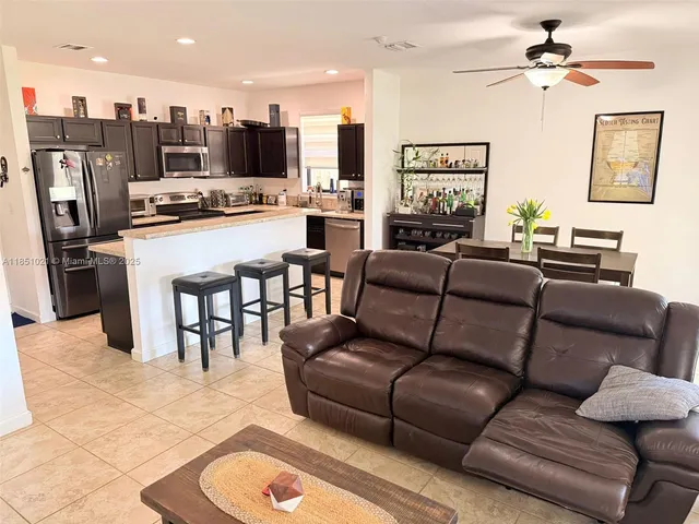 a living room with furniture kitchen view and a chandelier