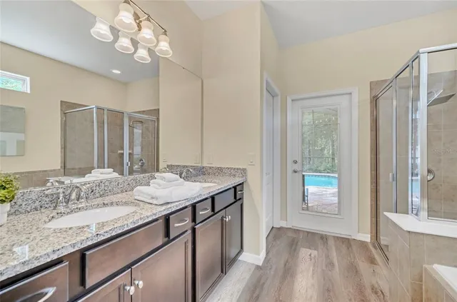 a bathroom with a tub a sink and a large mirror