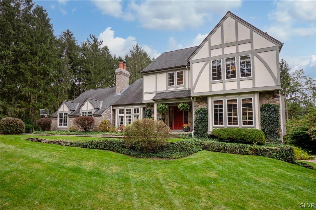 a front view of a house with a yard and trees
