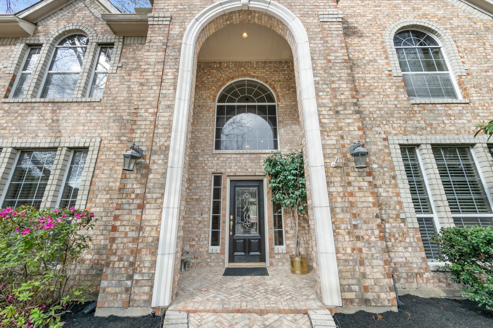 9510 Ashdown Forest Drive Spring, TX 77379 - Photo 2 of 50 The impressive two-story arched entry creates a striking welcome for guests. Elegant brickwork and tall windows emphasize the home’s grand architectural style.