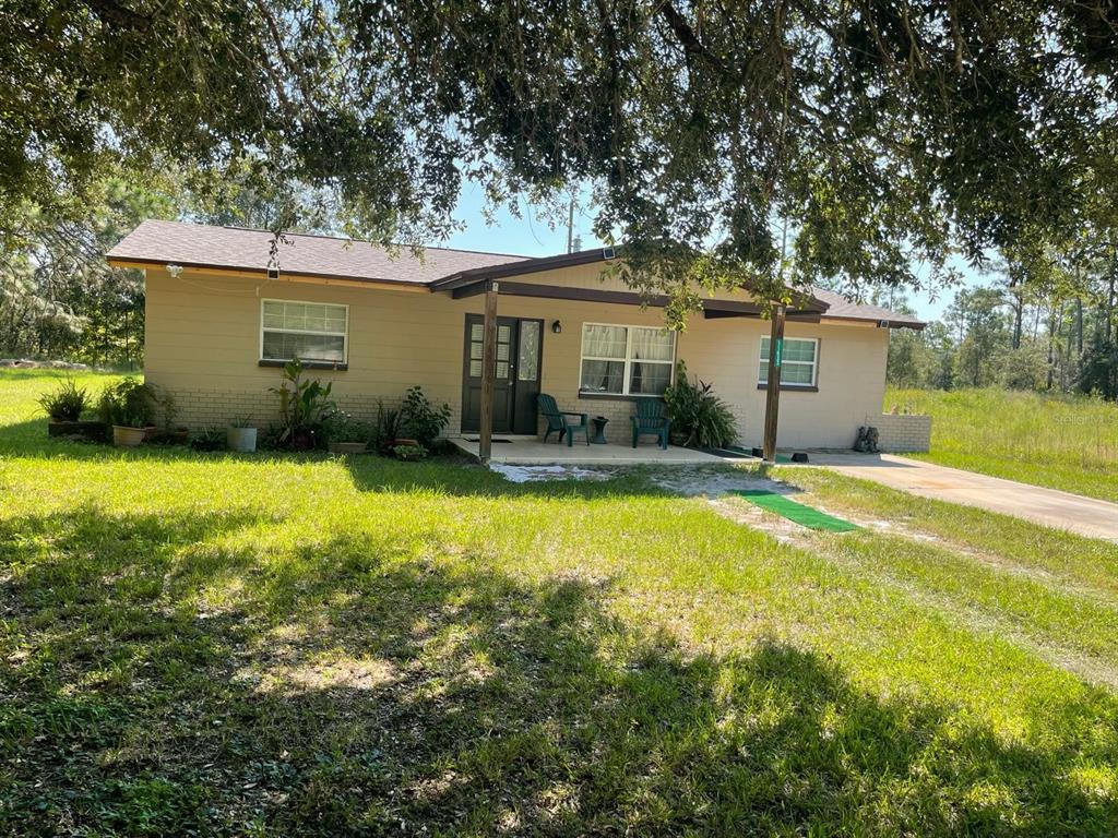 11433 South Rosewater Point Homosassa, FL 34446 - Photo 2 of 7 a backyard of a house with yard and outdoor seating