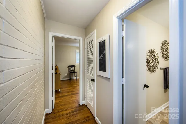 a view of a hallway to a livingroom with wooden floor and a rug