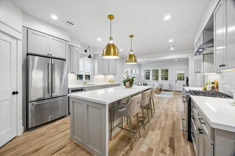 a kitchen with kitchen island a stove a sink a counter space and a center island