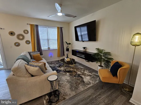 a kitchen with stainless steel appliances granite countertop a stove a refrigerator a sink a microwave and white cabinets with wooden floor