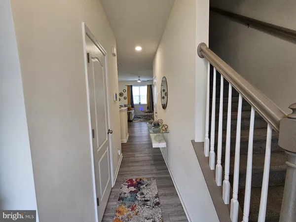 a view of a hallway with wooden floor and stairs