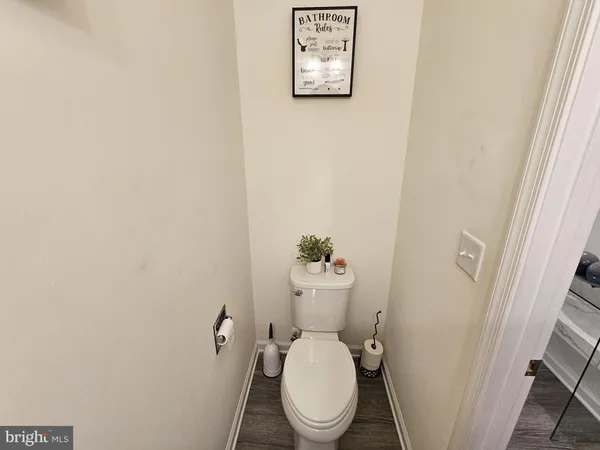 a white toilet sitting next to a white wall