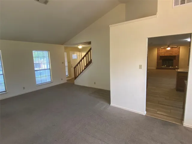 a large kitchen with stainless steel appliances wooden floor and a refrigerator