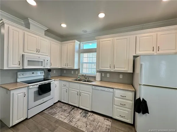 a kitchen with white cabinets sink and white appliances