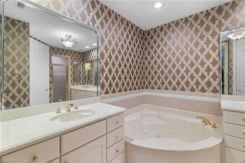 a bathroom with a sink a toilet a mirror and shower