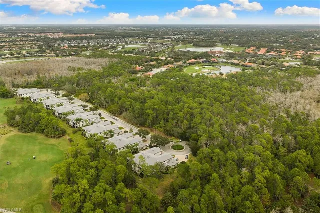 an aerial view of residential houses with outdoor space and a lake view
