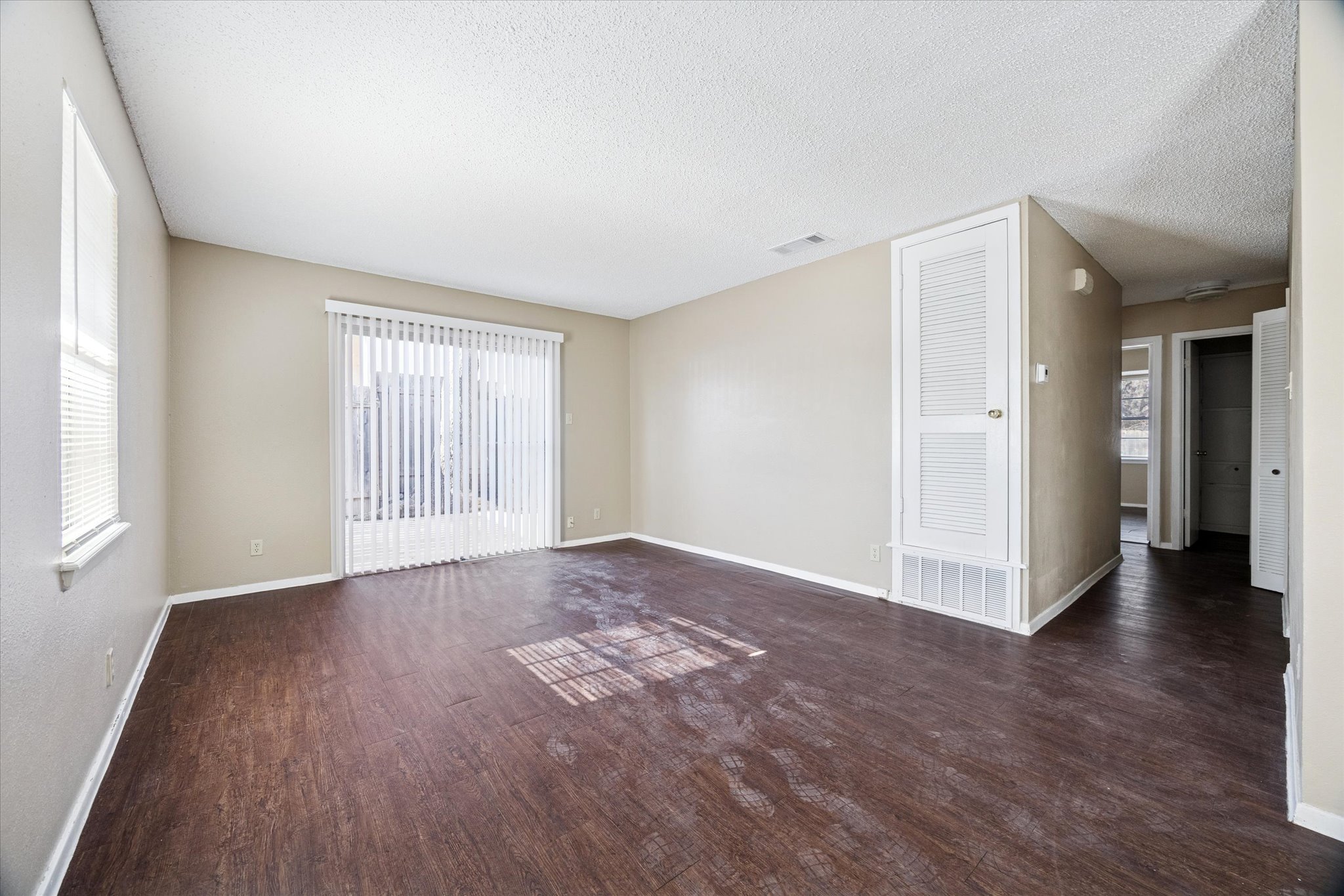 908 Kirschner Place, Unit B Austin, TX 78758 - Photo 2 of 10 Spare room featuring dark wood-style floors and a textured ceiling