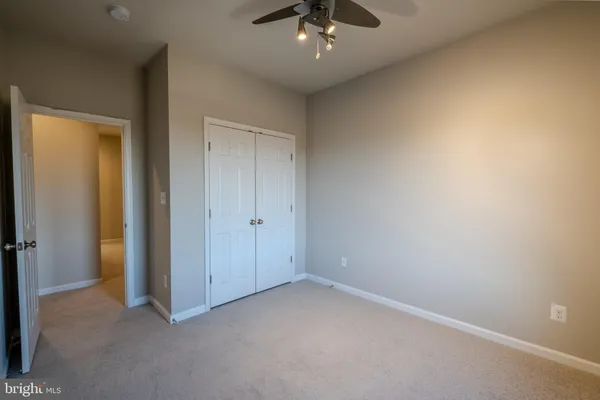 an empty room with a chandelier fan