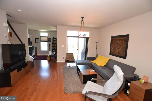 a living room with furniture a flat screen tv and wooden floor