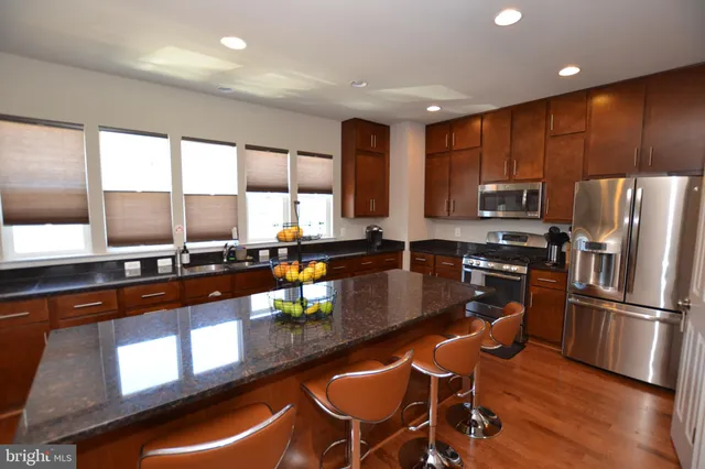 a kitchen with stainless steel appliances granite countertop counter space a sink and a refrigerator
