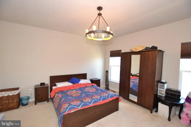 a bedroom with a bed dresser and a window