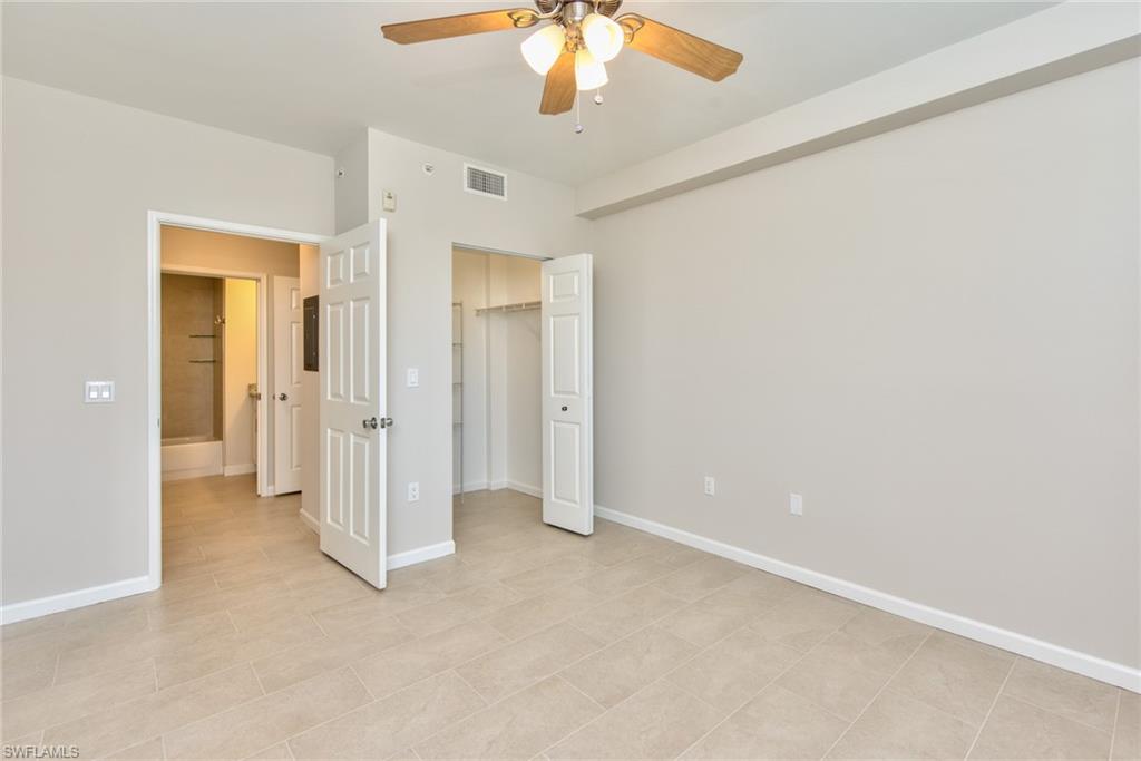 1200 Reserve Way, Unit 106 Naples, FL 34105 - Photo 11 of 31 en empty room with a chandelier fan and entryway