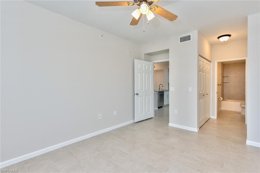 1200 Reserve Way, Unit 106 Naples, FL 34105 - Photo 12 of 31 an empty room with a bathroom and a chandelier fan