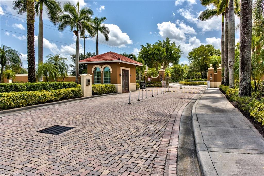 1200 Reserve Way, Unit 106 Naples, FL 34105 - Photo 21 of 31 a lawn chairs under an umbrella in front of house