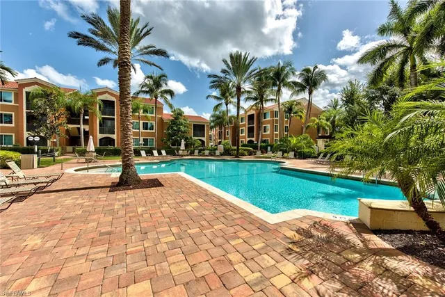 a view of a street with a building and palm trees