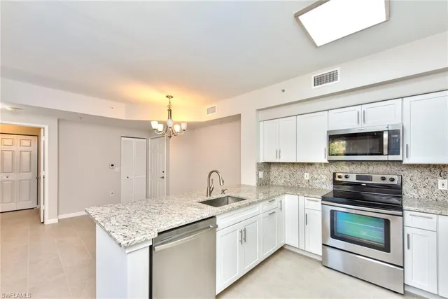 a kitchen with stainless steel appliances granite countertop a sink stove oven and refrigerator