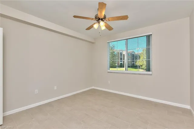 an empty room with a window and a fan