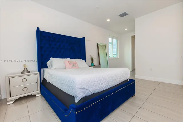 a spacious bedroom with a bed and a dresser