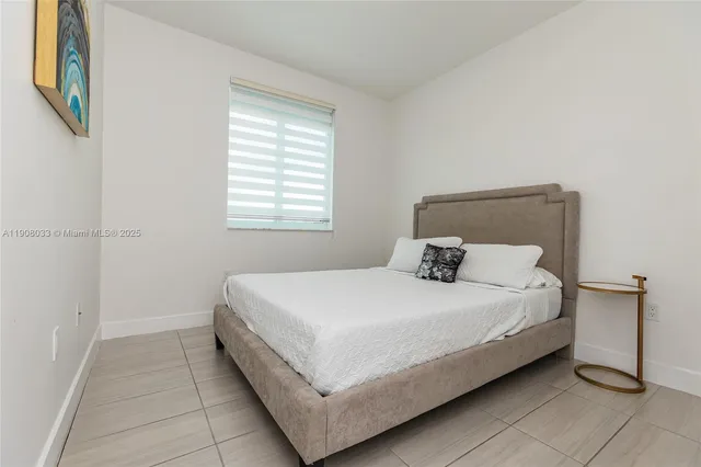 a large bed sitting in a bedroom next to a window