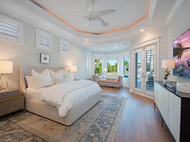 a spacious bedroom with a large bed and a flat screen tv