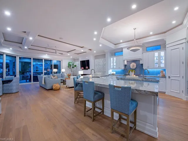 a kitchen with lots of counter and chairs