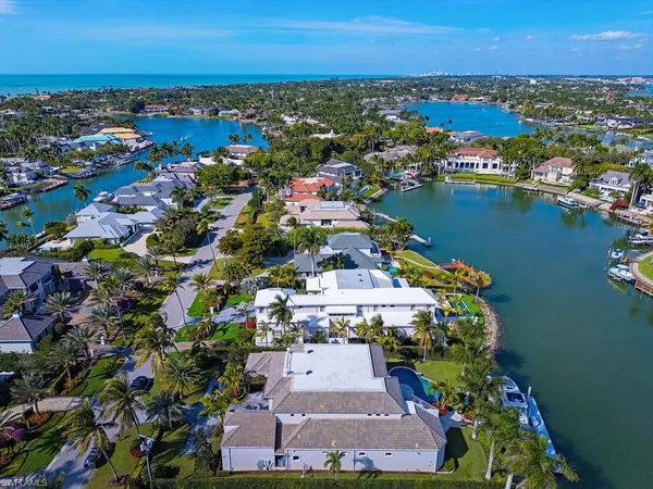 an aerial view of a city with lots of residential buildings ocean and mountain view in back