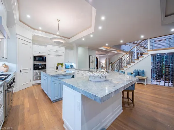 a kitchen with stainless steel appliances granite countertop a kitchen island a stove a table and a refrigerator