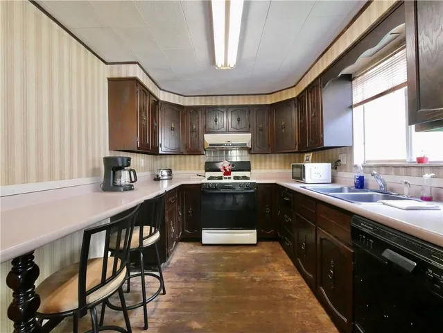 a kitchen with granite countertop a sink stove and cabinets