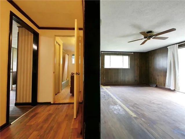 a view of hallway with wooden floor and a window
