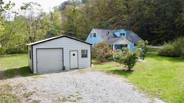 a view of a house with a yard and large tree