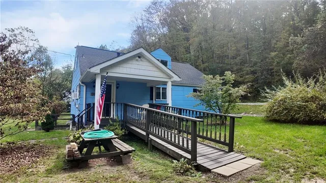 a view of house with a yard and entertaining space