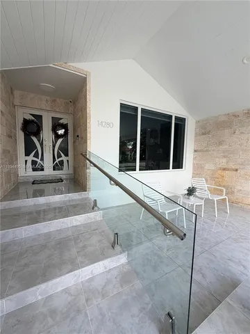 a living room with a large window and furniture