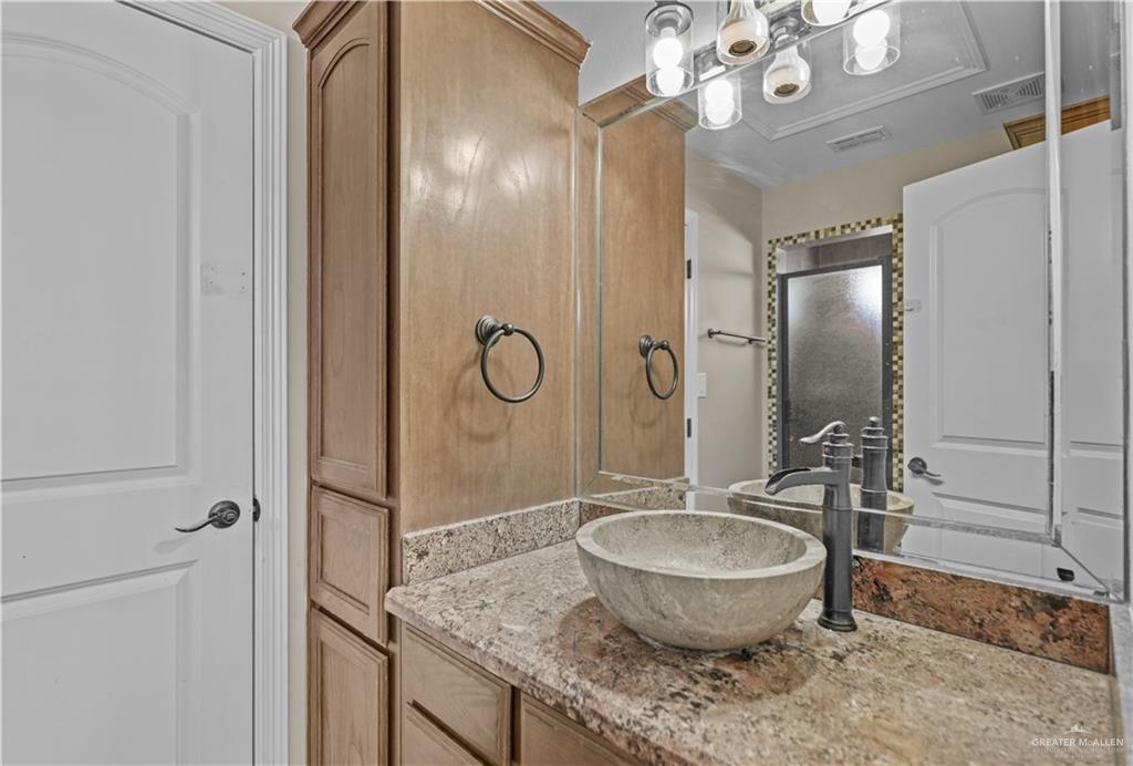 2608 Flamingo Avenue Mission, TX 78574 - Photo 14 of 27 a bathroom with a granite countertop sink a toilet and a mirror