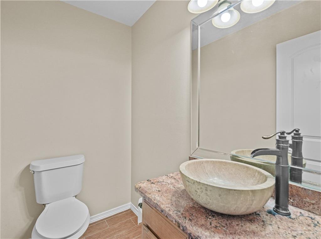 2608 Flamingo Avenue Mission, TX 78574 - Photo 19 of 27 a bathroom with a granite countertop toilet a sink and a mirror