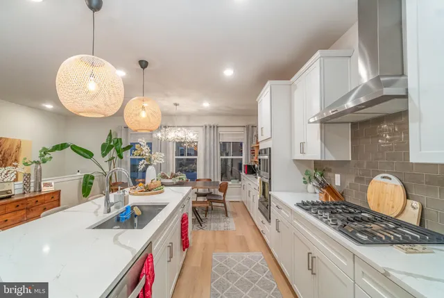 a very nice looking kitchen with granite countertop a stove and a wooden floors