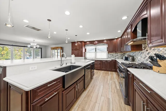 a kitchen with stainless steel appliances granite countertop a sink stove and refrigerator