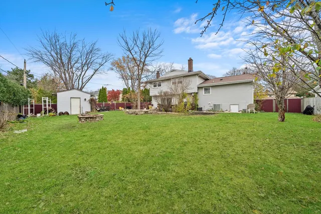 a view of a white house that has a tree in front of it