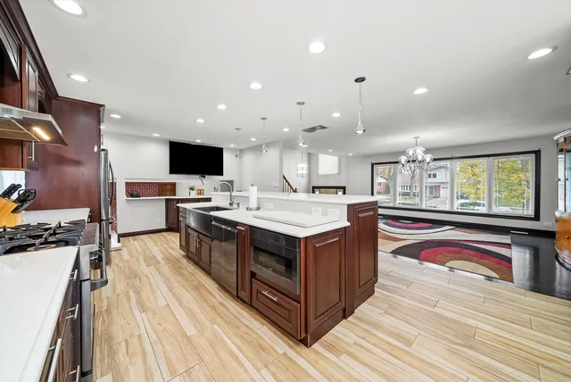 a kitchen with stainless steel appliances granite countertop a stove and a wooden floors